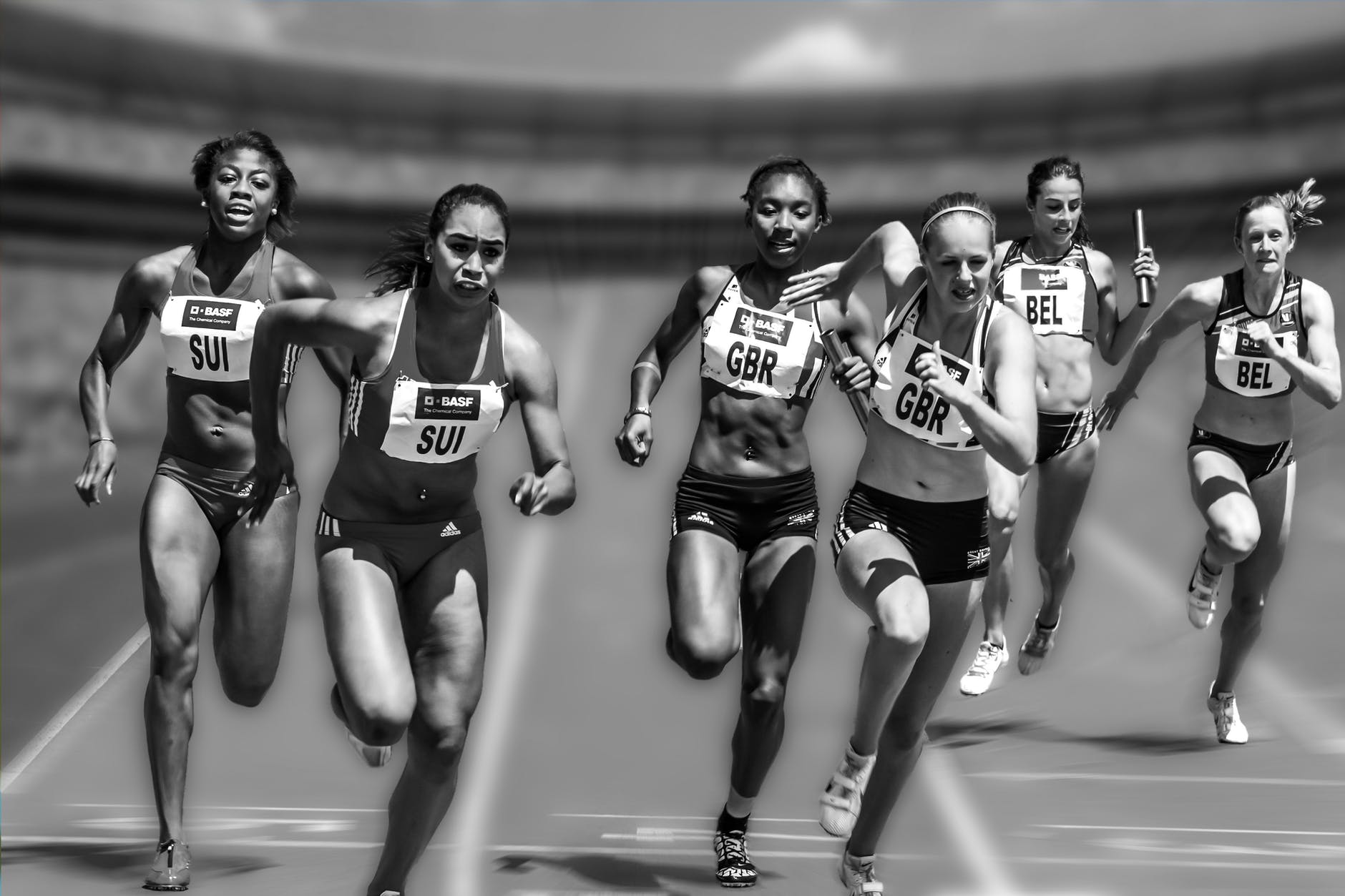 A photo of women athletes running during a relay race